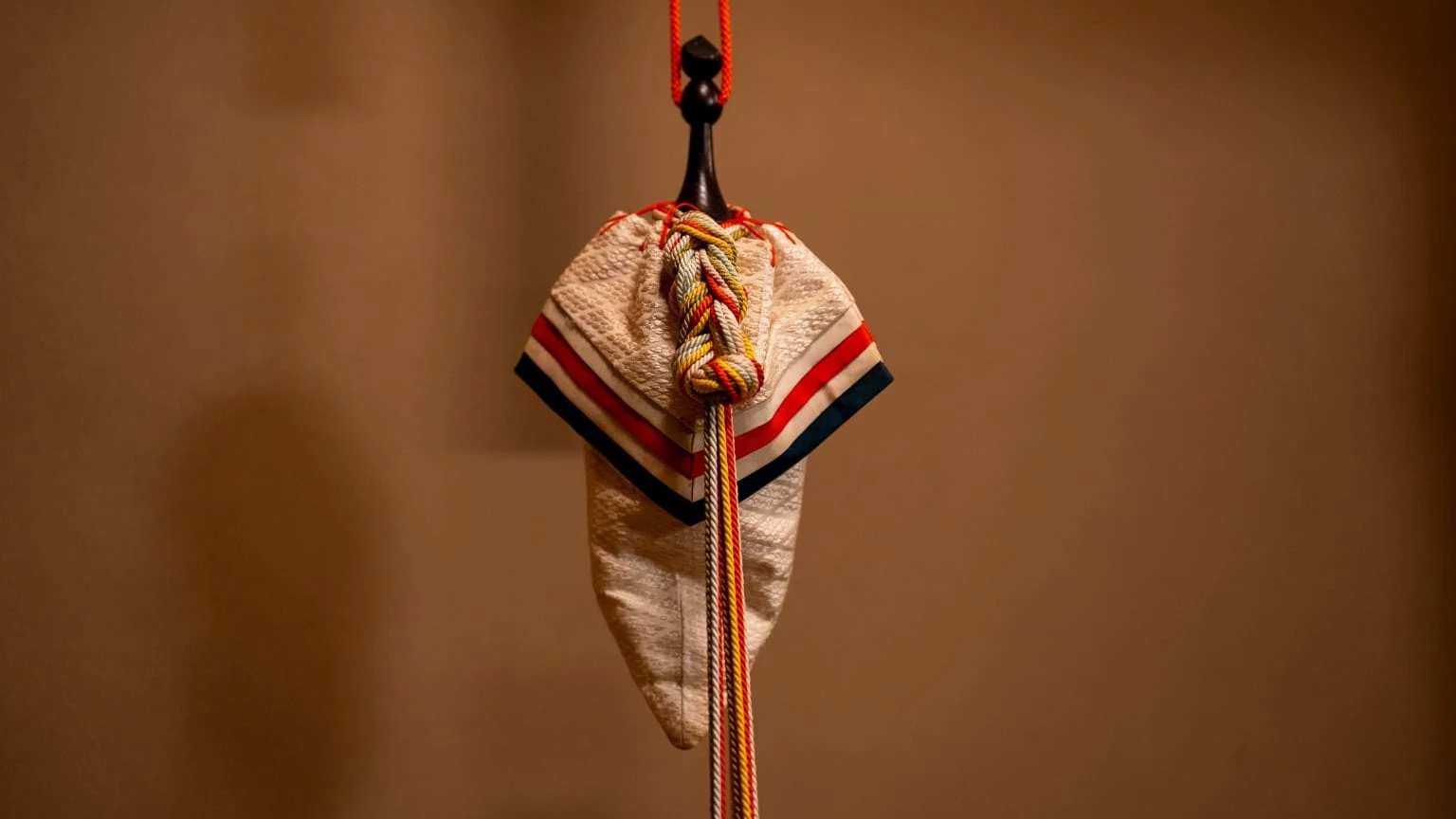 五色の組紐に彩られた訶梨勒(かりろく)。邪気払いの意味をこめて、床脇の飾りに。